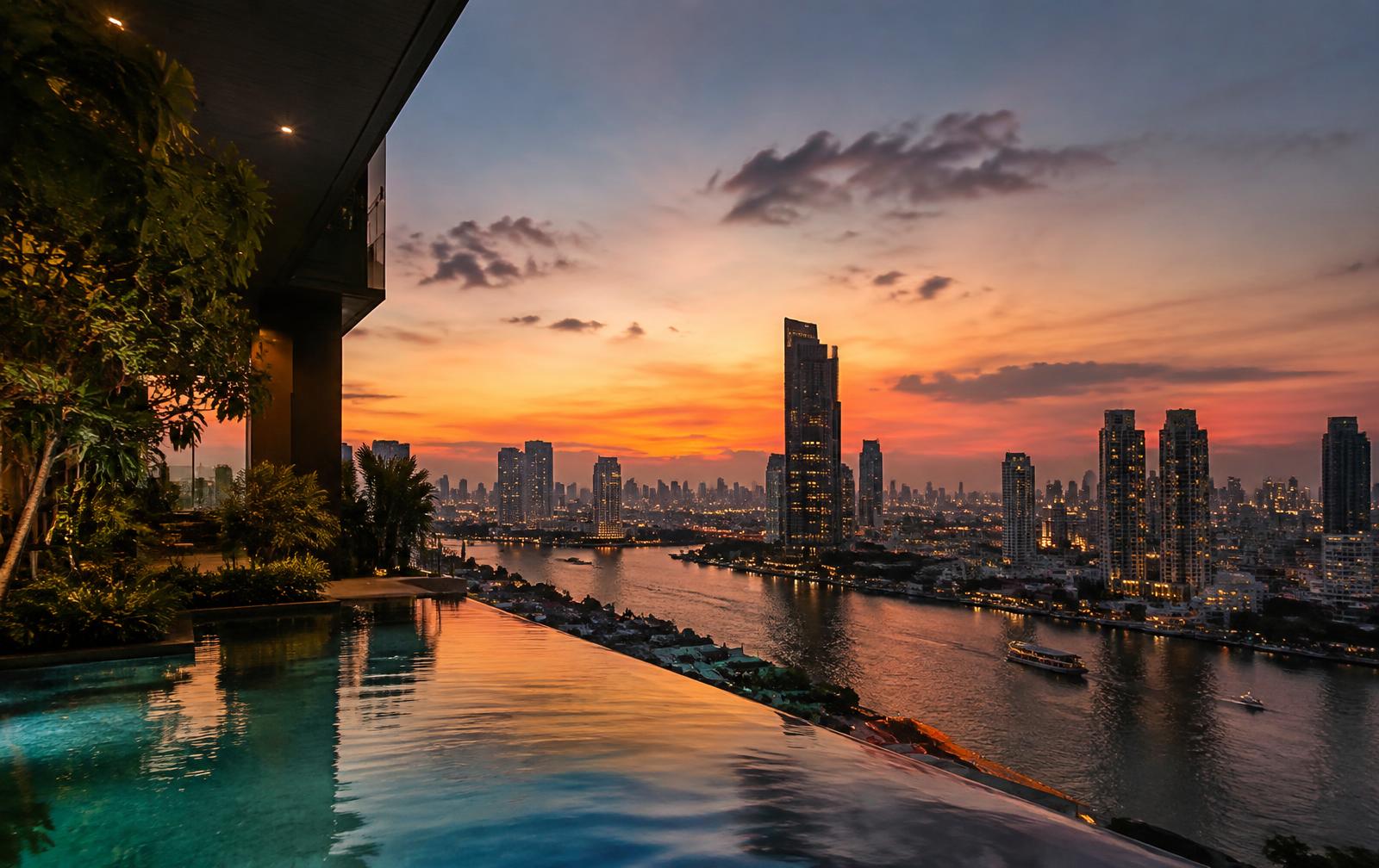 Bangkok skyline at dusk from a riverside condo pool